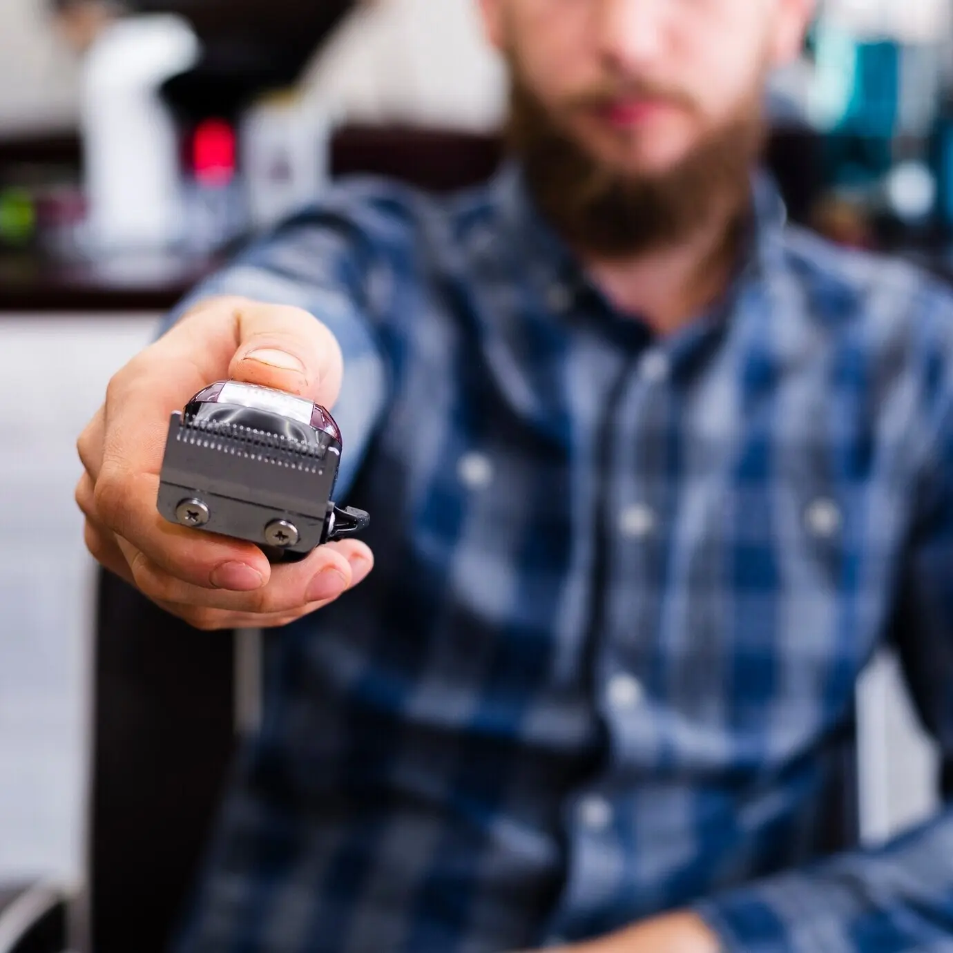 Мужчина демонстрирует необходимые принадлежности для ухода за бородой, крупный план.