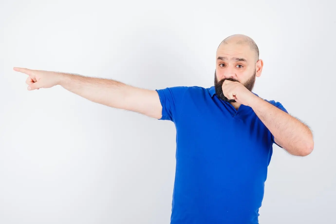 Вид спереди: молодой мужчина в синей рубашке указывает в сторону и выглядит встревоженным.